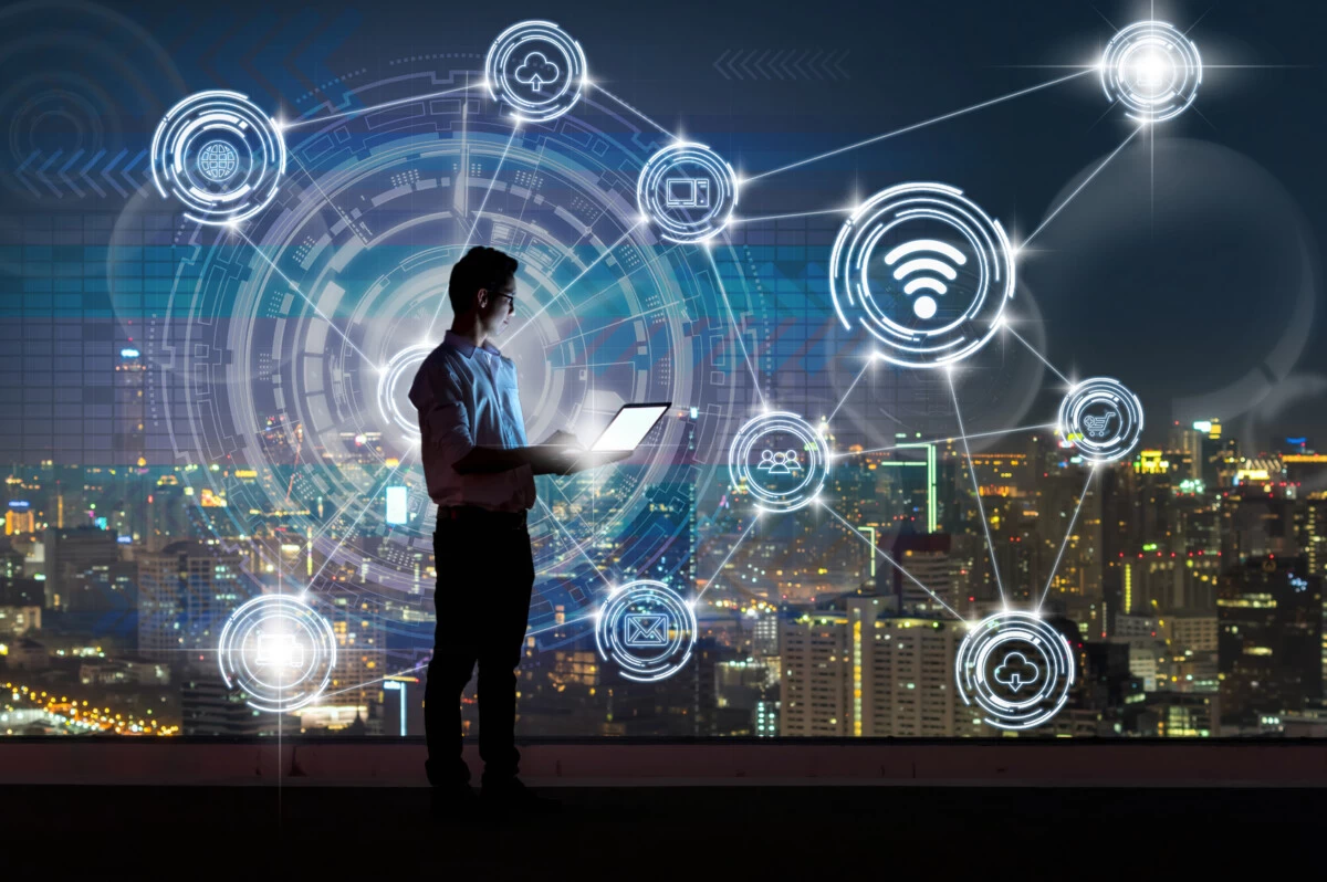 Asian businessman standing and using the laptop showing Wireless communication connecting of smart city Internet of Things Technology over the cityscape background, technology and innovation concept Dijital cagda