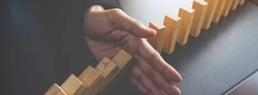 problem solving close up view hand business woman stopping falling blocks table concept about taking responsibility e1633942106516